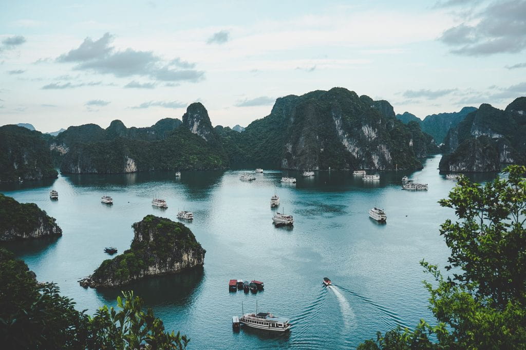 A view to the bay in Vietnam with boats and rocks.